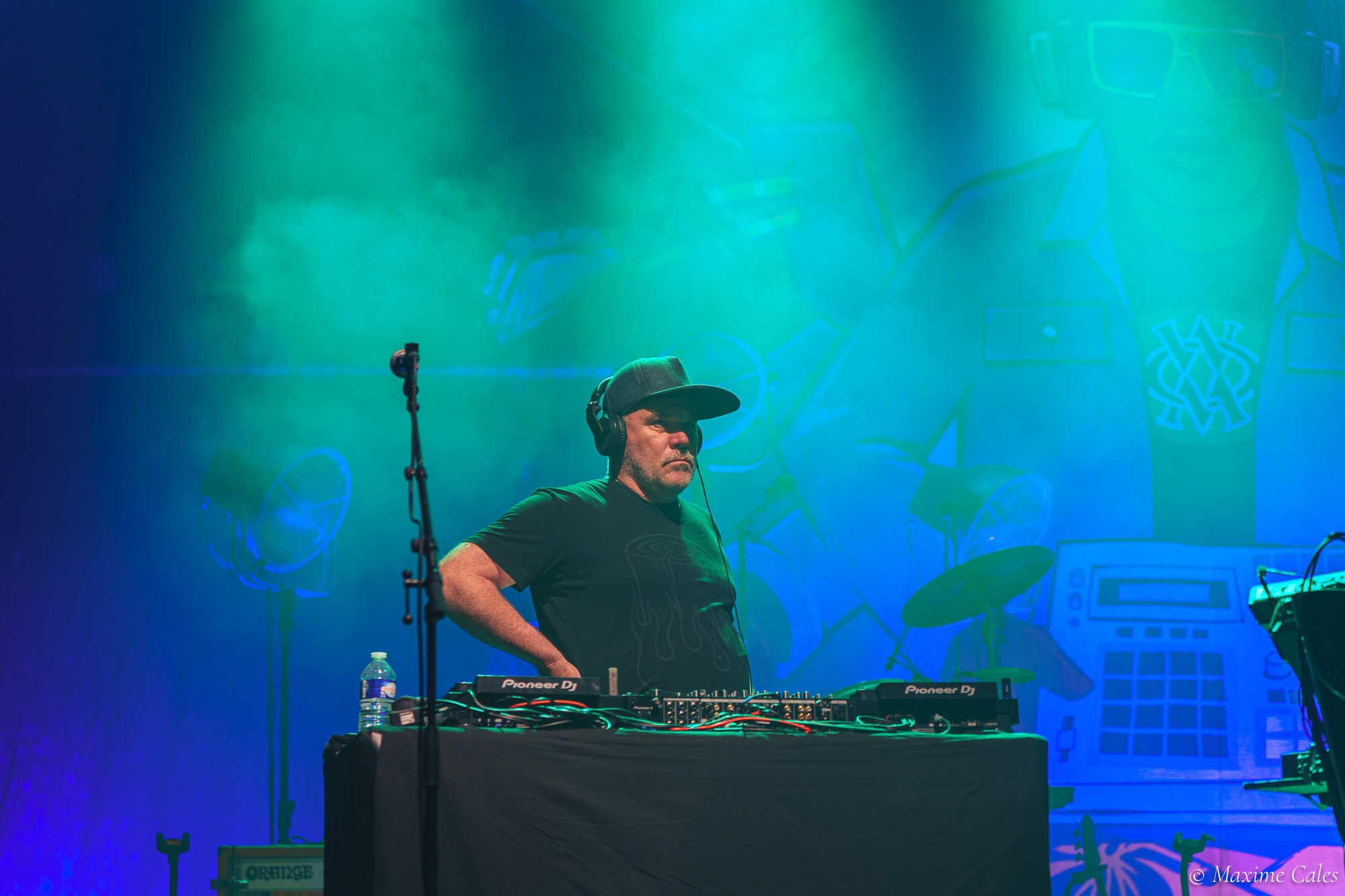 Musicien de Fat Freddy's Drop aux platines dans une lumière bleu-vert